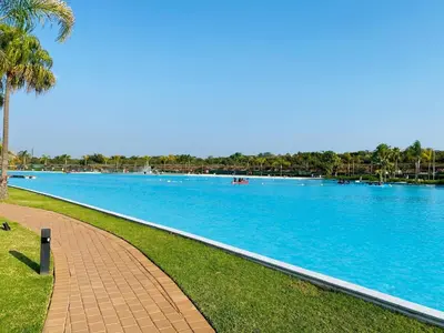 a large swimming pool with blue water and palm trees at The Blyde Pretoria 2 bed 2 bath apartment in Pretoria