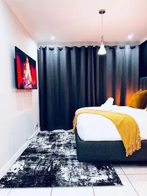 a bedroom with a bed and a black curtain at The Blyde Pretoria 2 bed 2 bath apartment in Pretoria