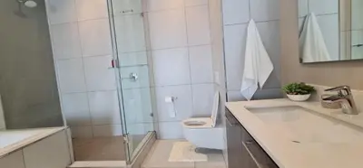 a bathroom with a shower and a toilet and a sink at Trilogy Luxurious Resorts in Pretoria