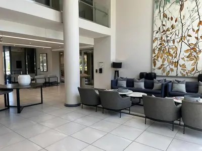 a lobby with couches and tables in a building at Trilogy Luxurious Resorts in Pretoria