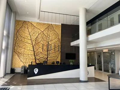 an office lobby with a wall with a tree mural at Trilogy Luxurious Resorts in Pretoria