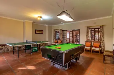 a room with two pool tables and ping pong balls at Misty Mountain in Sabie