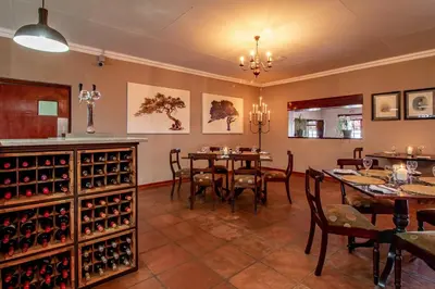 a dining room with a table and some wine bottles at Misty Mountain in Sabie