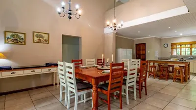 a kitchen and dining room with a wooden table and chairs at Misty Mountain in Sabie