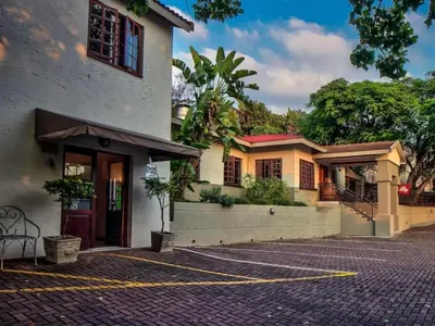 a house with a brick driveway in front of it at Sabores Lodge and Restaurant in Nelspruit