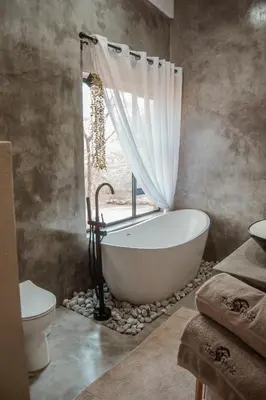 a bathroom with a bath tub and a window at The Hyde in Marloth Park