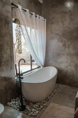 a bath tub in a bathroom with a window at The Hyde in Marloth Park
