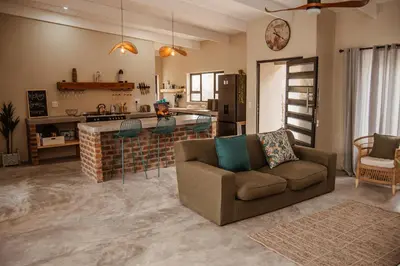 a living room with a couch and a kitchen at The Hyde in Marloth Park