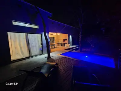 a house with a blue pool in the dark at The Hyde in Marloth Park