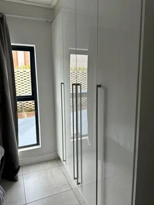 a glass refrigerator in a room with a window at Home at Polo - Classy Comfort in Midrand