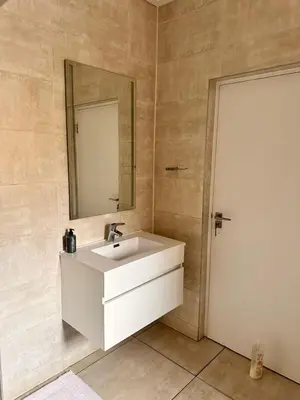 a bathroom with a white sink and a mirror at Home at Polo - Classy Comfort in Midrand
