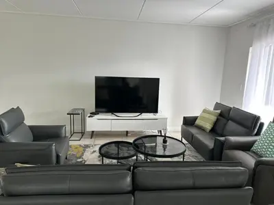 a living room with couches and a flat screen tv at Home at Polo - Classy Comfort in Midrand