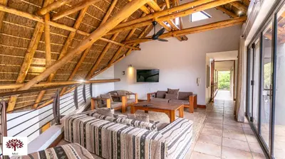 a living room with couches and a wooden ceiling at Zebula Golf and Wildlife Estate - Tuskers Retreat Pax 20 in Warmbaths