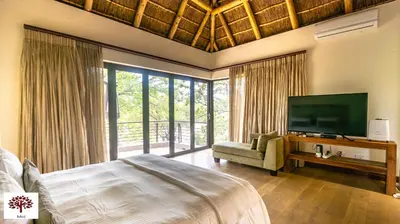 a bedroom with a bed and a flat screen tv at Zebula Golf and Wildlife Estate - Tuskers Retreat Pax 20 in Warmbaths