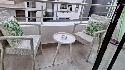 a balcony with chairs and a table and a tub at The Luxury Apartments in Midrand