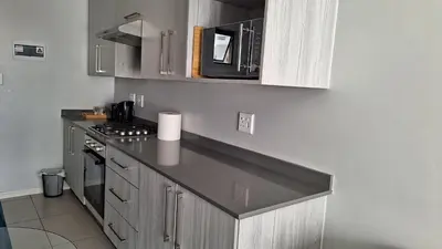 a kitchen with a counter top and a microwave at The Luxury Apartments in Midrand