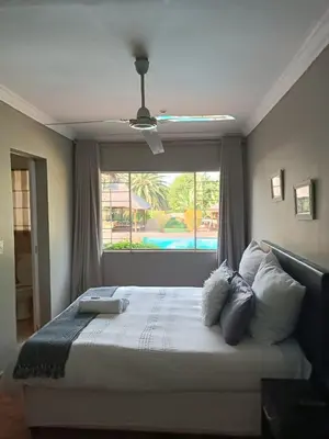 a bedroom with a large bed with a window at Glen Rest Country Lodge in Midrand