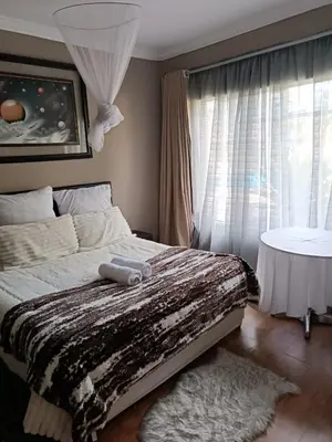a bedroom with a large bed and a window at Glen Rest Country Lodge in Midrand