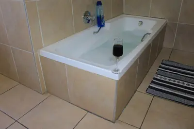 a bath tub with a glass of wine in it at Glen Rest Country Lodge in Midrand