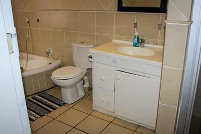 a bathroom with a toilet and a sink and a tub at Glen Rest Country Lodge in Midrand