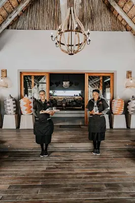two women standing in a room with plates of food at Bongela Private Game Lodge in Vaalwater