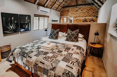 a bedroom with a bed and a brick wall at Bongela Private Game Lodge in Vaalwater