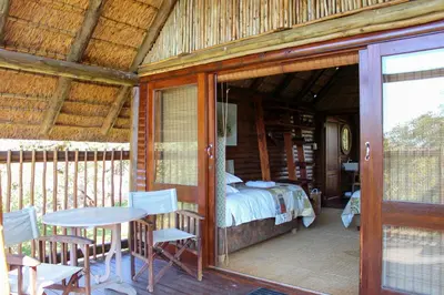 a room with a bed and a table and chairs at Bongela Private Game Lodge in Vaalwater