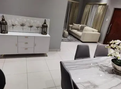 a white living room with a table and a couch at Kings view exclusive villas in Petronella