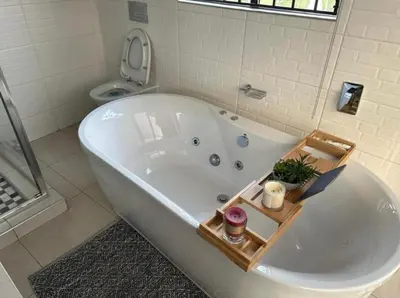 a white bath tub in a bathroom with a toilet at Kings view exclusive villas in Petronella