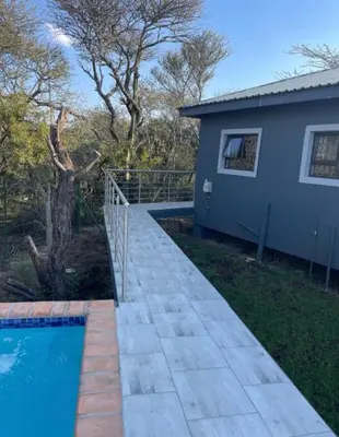 a house and a swimming pool in front of a house at Kings view exclusive villas in Petronella