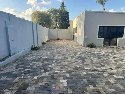 a brick driveway in front of a white building at Nouvelle Ere Beauty Spa & Boutique Guesthouse in Centurion