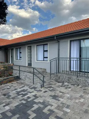 a white house with a brick patio in front of it at Nouvelle Ere Beauty Spa & Boutique Guesthouse in Centurion