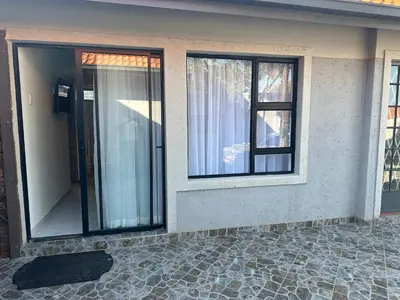 a house with two windows and a stone patio at Nouvelle Ere Beauty Spa & Boutique Guesthouse in Centurion