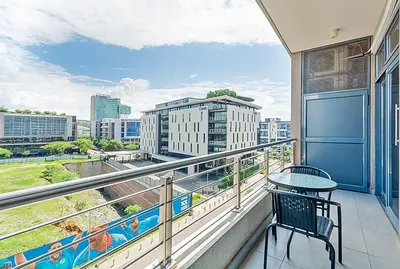 a balcony with a table and a view of a city at Capital Residence Apartment in Menlyn Maine in Pretoria