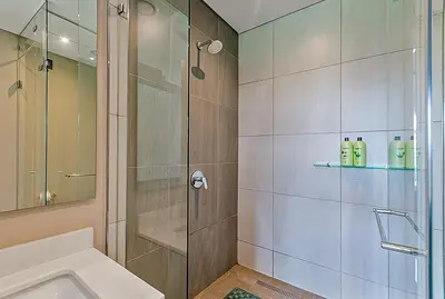 a bathroom with a shower with a glass door at Capital Residence Apartment in Menlyn Maine in Pretoria