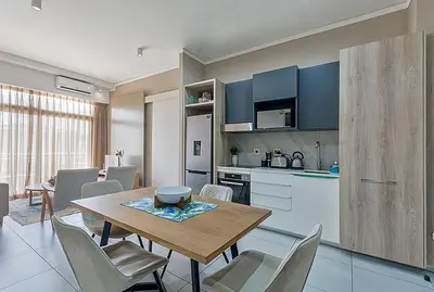 a kitchen and dining room with a table and chairs at Capital Residence Apartment in Menlyn Maine in Pretoria