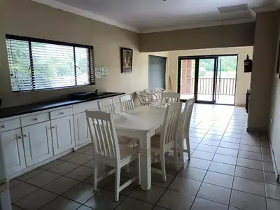 a dining room with a white table and chairs at Riverside Lodge - Loerie in Cobalt