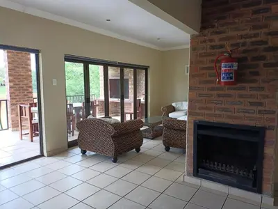 a living room with a brick fireplace and chairs at Riverside Lodge - Loerie in Cobalt