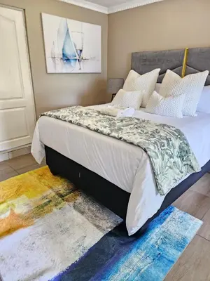 a bedroom with a bed and a rug at Batuka Damview Lodge in Tshakhuma