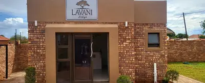 a brick building with a door and a sign on it at Lavani Lodge in Lerulaneng