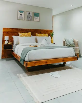 a bedroom with a large bed with a wooden headboard at Lavani Lodge in Lerulaneng