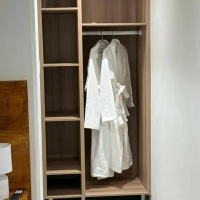 a wooden closet with white clothes in it at Lavani Lodge in Lerulaneng