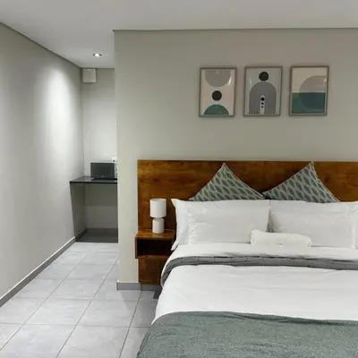 a bedroom with a large bed with a wooden headboard at Lavani Lodge in Lerulaneng