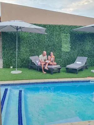 a man and a child sitting next to a swimming pool at Lavani Lodge in Lerulaneng