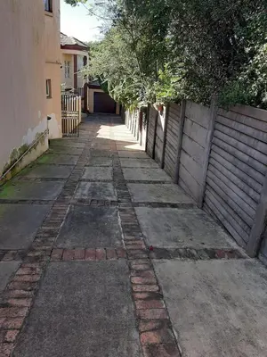 an empty alley with a fence and a building at Villa at Wekker in Pretoria