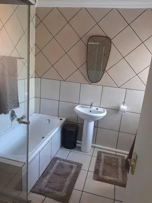 a bathroom with a sink and a toilet and a tub at Villa at Wekker in Pretoria