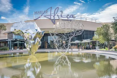 a fountain in front of a shopping center with a building at Ellipse Kepler High-Rise 2-Bedroom en-suite Luxury Apartment in Midrand