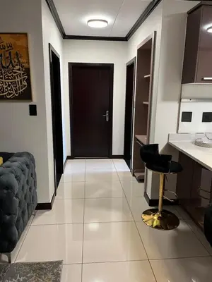 a hallway with a black door and a black stool at Lake view Apartment and suite in Midrand