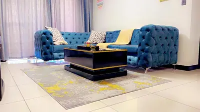 a living room with a blue couch and a table at Lake view Apartment and suite in Midrand