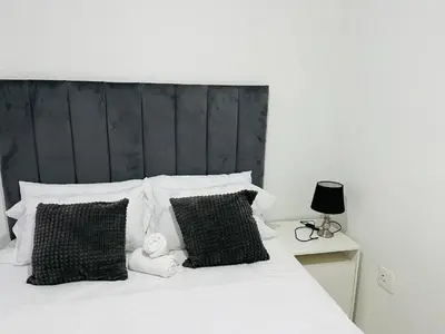 a bedroom with a white bed with black and white pillows at Mohwelere Guest House in Pretoria